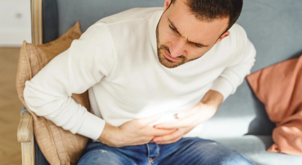 young-man-writhing-in-a-stomach-pain-2023-11-27-04-57-06-utc@2x-1