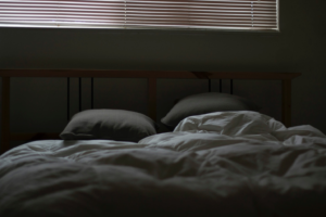 A bed with messy sheets and pillows, suggesting a restless night's sleep.