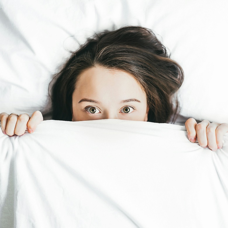 a woman lying in bed, unable to sleep