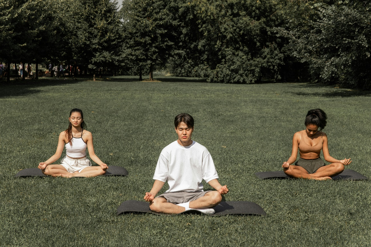 Group meditating in a park, demonstrating relaxation techniques to manage smoking cravings.